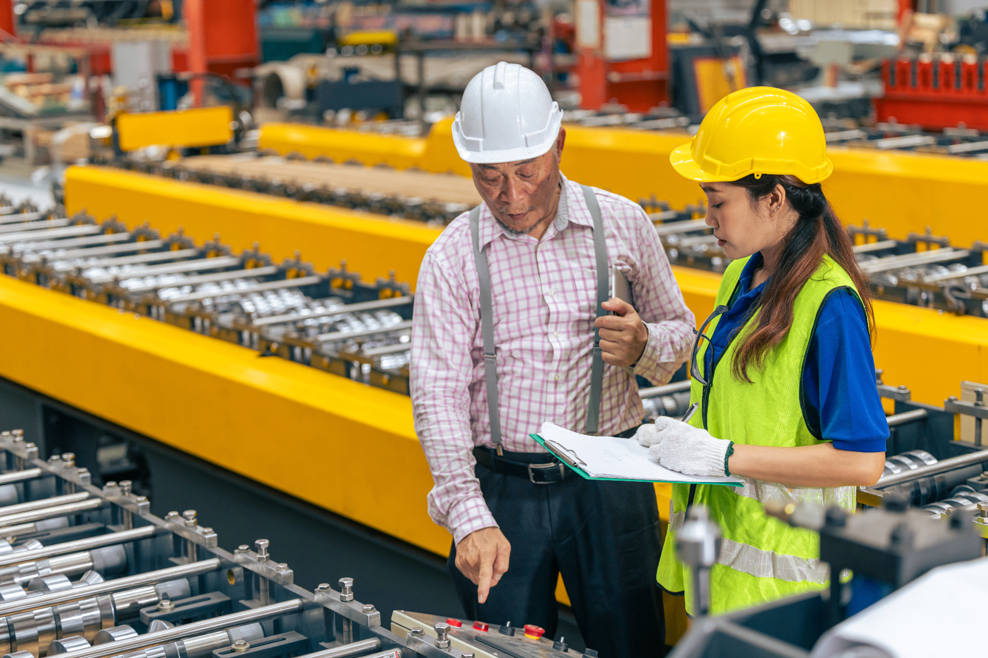 Diverse manufacturing workers speaking together on the factory floor